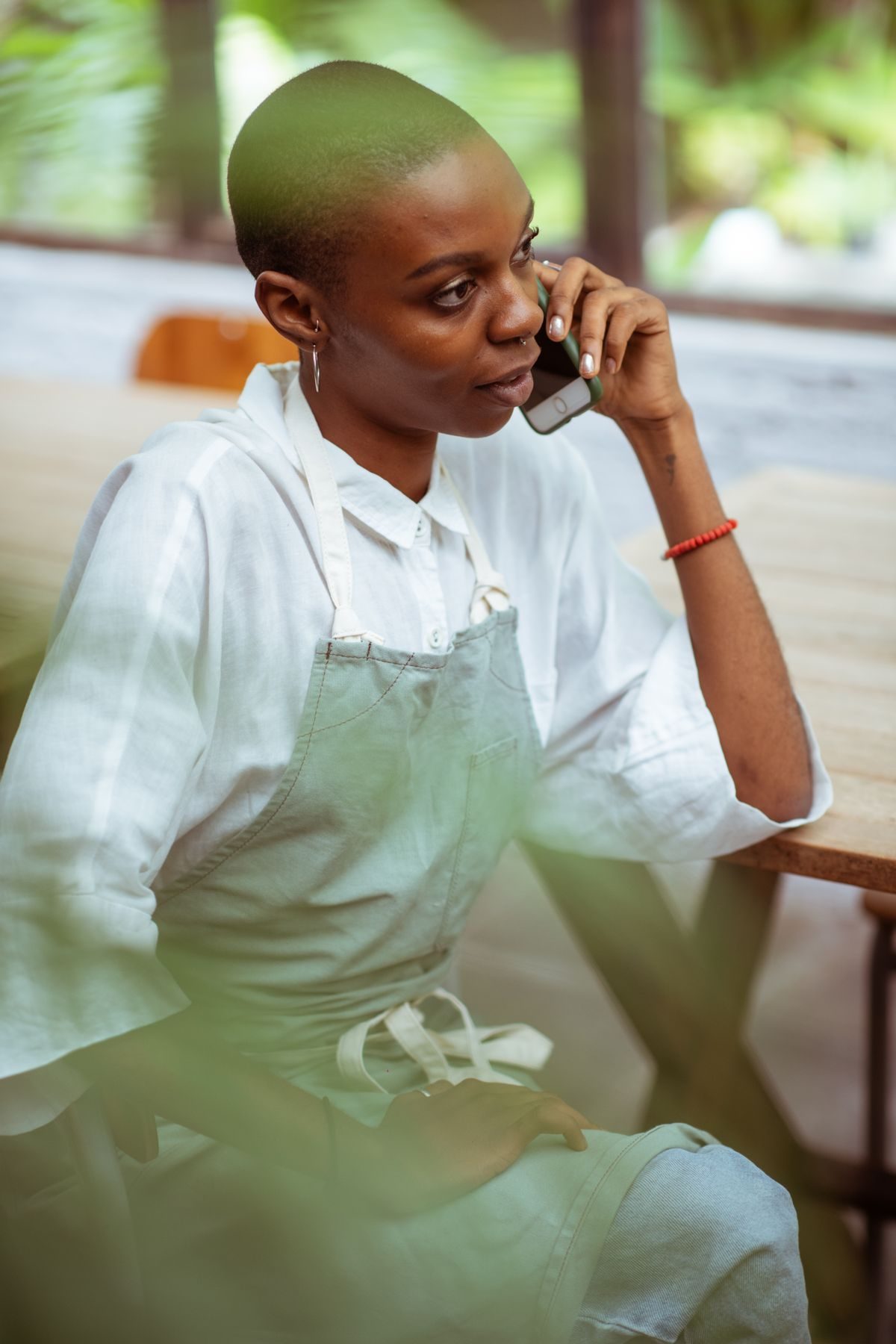 Owner in an apron answering a customer on the phone