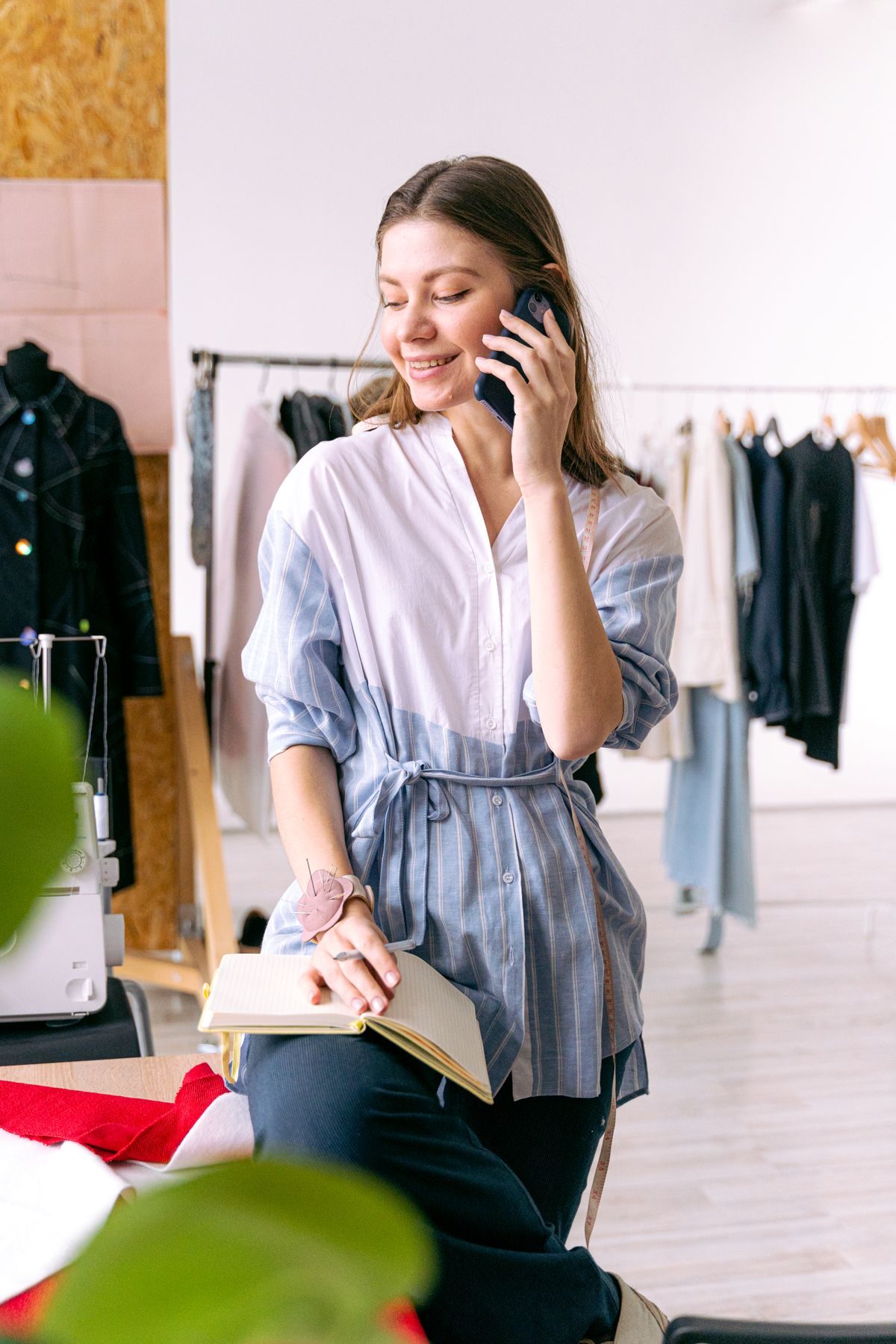 Fashion studio owner on the phone among her rails