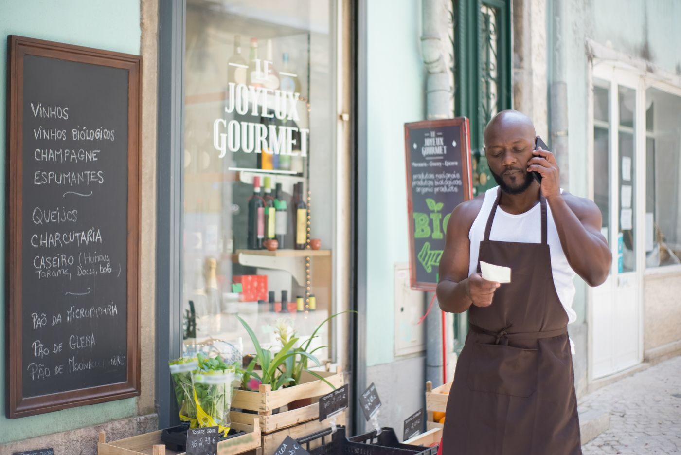 Restaurant owner taking a booking on the phone outside his kitchen
